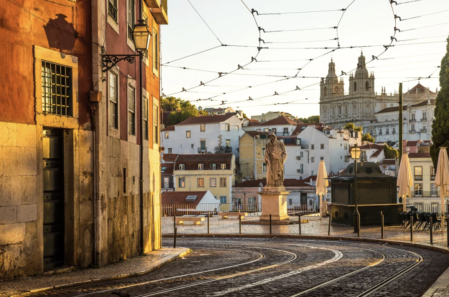 Lisbon rooftops and Tagus River at sunset — golden hour view from a hilltop miradouro on the Lisbon Sunset tuk tuk tour